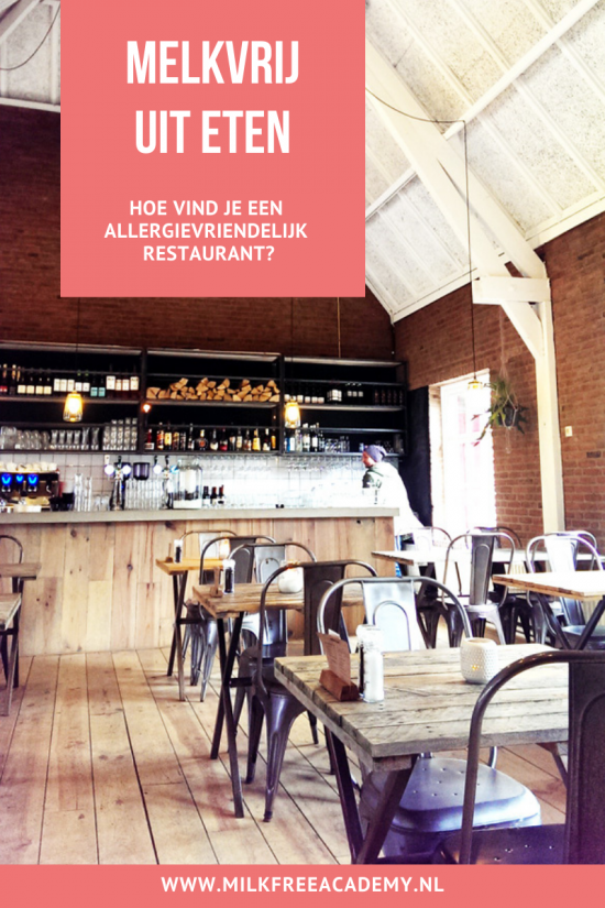 Melkvrij uit eten - op de foto een restaurantsetting in een grote schuur met bakstenen muren, houten tafels en metalen stoelen.